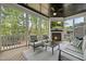 Comfortable screened porch features a fireplace, TV, cozy seating, and tree lined views at 1305 Reservoir View Ln, Wake Forest, NC 27587