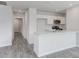 Bright, open kitchen featuring white cabinetry, modern appliances, marble countertops, and gray wood-look flooring at 137 Lillian Ct, Roxboro, NC 27573