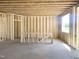 Interior view of the new home construction, featuring wooden framing, concrete floor and window at 139 Fast Pitch Ln, Four Oaks, NC 27524