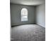 Bedroom with neutral walls and carpet, offering a view through the arched window at 147 Landon Pl, Roxboro, NC 27573