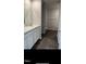 Modern bathroom with white cabinets, double sinks, and gray wood flooring leading to separate toilet area at 148 Landon Pl, Roxboro, NC 27573