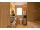 Galley kitchen featuring wood cabinets, stainless steel sink, and white appliances at 1505 Kendall Dr, Durham, NC 27703
