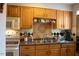 A well-organized kitchen featuring wood cabinets, a stainless steel sink, and black and white backsplash at 1505 Kendall Dr, Durham, NC 27703