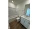 A full bathroom features a tub with shower, toilet, vanity, and wood-look flooring at 168 Parker Ln, Mebane, NC 27302