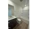 Bathroom featuring a shower-tub combo, dark vanity, and tile floors at 172 Parker Ln, Mebane, NC 27302