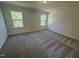 Bright bedroom with two windows and plush gray carpeting at 172 Parker Ln, Mebane, NC 27302