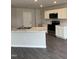 Kitchen with stainless steel appliances, white cabinets, an island, and dark floors at 173 Lillian Ct, Roxboro, NC 27573