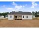 Backyard of a new home, featuring a small deck and white siding, surrounded by a freshly seeded lawn at 203 Sourgum Ct, Zebulon, NC 27597