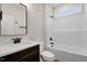 This bathroom features a vanity with dark wood cabinets, quartz countertop, modern fixtures, and a tub at 203 Sourgum Ct, Zebulon, NC 27597
