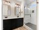 A bathroom with double sink vanity, quartz countertop, and a spacious glass enclosed tile shower is shown at 203 Sourgum Ct, Zebulon, NC 27597