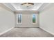 Bright bedroom with neutral carpet, tray ceiling, and two windows offering natural light at 203 Sourgum Ct, Zebulon, NC 27597