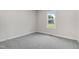 This bedroom with neutral walls and carpet offers a view of the outdoors from the window at 203 Sourgum Ct, Zebulon, NC 27597