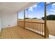 A relaxing covered deck is shown with wood flooring and a view of the large backyard and blue sky at 203 Sourgum Ct, Zebulon, NC 27597