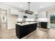 Bright kitchen features white cabinets, dark countertops, and a large island with modern lighting at 203 Sourgum Ct, Zebulon, NC 27597