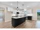 Well-appointed kitchen with an island, modern appliances, and stylish light fixtures at 203 Sourgum Ct, Zebulon, NC 27597