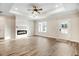 Spacious living room with wood floors, a ceiling fan, and an electric fireplace at 203 Sourgum Ct, Zebulon, NC 27597