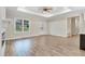 Bright living room with wood floors, a fireplace, recessed lighting, and large windows overlooking the yard at 203 Sourgum Ct, Zebulon, NC 27597