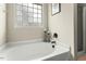 Large tub with tile window and black fixtures, offering a peaceful retreat at 218 Darecrest Ln, Wendell, NC 27591