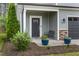 Inviting front porch with seating, potted plants, stone accents and manicured landscaping at 218 Darecrest Ln, Wendell, NC 27591