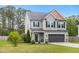 Well-maintained gray two-story home with a two-car garage, set against a backdrop of lush green trees at 218 Darecrest Ln, Wendell, NC 27591