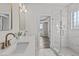 Bright primary bathroom featuring double sinks, quartz countertops, and a glass-enclosed shower at 241 Connelly Way, Zebulon, NC 27597