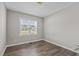 A modern bedroom featuring hardwood floors and ample natural lighting from large window at 241 Connelly Way, Zebulon, NC 27597