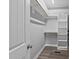 Walk-in closet featuring wood floor, built-in shelving and hanging rods for ample storage at 241 Connelly Way, Zebulon, NC 27597