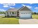 Charming home featuring a well-manicured lawn, gray siding, and a two-car garage at 241 Connelly Way, Zebulon, NC 27597