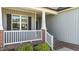 Close up of the home's entryway and cozy front porch with white railing and brick accents at 241 Connelly Way, Zebulon, NC 27597