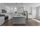 A modern kitchen boasts white cabinets, stainless appliances, and an island at 241 Connelly Way, Zebulon, NC 27597