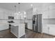 A modern kitchen boasts white cabinets, stainless appliances, and an island at 241 Connelly Way, Zebulon, NC 27597