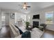 Open-concept living room featuring a fireplace and seamless flow into the modern kitchen at 241 Connelly Way, Zebulon, NC 27597