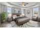 Tranquil main bedroom featuring a large bed, neutral colors, and ample natural light from surrounding windows at 241 Connelly Way, Zebulon, NC 27597