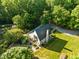 Aerial view of modern home featuring a chimney and a beautiful garden surrounded by lush trees and greenery at 2509 Nc 57, Hillsborough, NC 27278