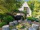 Backyard with tree stump seating area around a stone fire pit near the house at 2509 Nc 57, Hillsborough, NC 27278