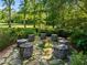 Secluded backyard with unique tree stump seating surrounding a stone fire pit area at 2509 Nc 57, Hillsborough, NC 27278