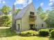 Unique home showcasing stucco exterior, balcony, peaked roof, and verdant lawn at 2509 Nc 57, Hillsborough, NC 27278