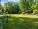 Spacious yard showcasing lush grass, trees, and fencing at 2509 Nc 57, Hillsborough, NC 27278