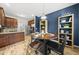 This dining area features a round wooden table with a stylish bookshelf, complementing the kitchen design at 2808 Polesdon Ct, Raleigh, NC 27615