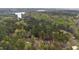 Aerial view of a wooded community showcasing a beautiful lake and lush green surroundings at 3011 Bourbon St, Sanford, NC 27332