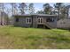 Home featuring a backyard with grassy lawn and stairs to the deck at 3011 Bourbon St, Sanford, NC 27332