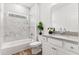 Bathroom with tub and shower combo featuring white cabinets, stylish fixtures, and marble tile at 3011 Bourbon St, Sanford, NC 27332