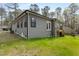 Gray home with exterior siding, green grass, and wooden deck with stairs at 3011 Bourbon St, Sanford, NC 27332