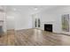Bright living room features a fireplace, wood floors, white trim, and access to a patio at 3011 Bourbon St, Sanford, NC 27332
