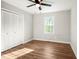 Bright bedroom featuring a closet and hardwood floors, with natural light from the window at 305 Gillis Rd, Roxboro, NC 27574