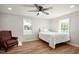 This bedroom features wood floors, a ceiling fan, and two bright windows at 305 Gillis Rd, Roxboro, NC 27574