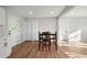 Bright dining room featuring white trim, natural light, laminate flooring, and a 4-seat dining table at 305 Gillis Rd, Roxboro, NC 27574