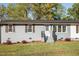 Charming home featuring a well-kept lawn and gray painted brick exterior, creating a welcoming curb appeal at 305 Gillis Rd, Roxboro, NC 27574