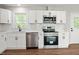 Bright kitchen with white cabinets, stainless steel appliances, and a view of the backyard from the window at 305 Gillis Rd, Roxboro, NC 27574