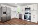 Modern kitchen featuring stainless steel appliances, sleek white cabinets, and light-colored subway tile backsplash at 305 Gillis Rd, Roxboro, NC 27574
